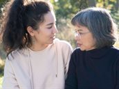 Moeder en dochter naast elkaar in park